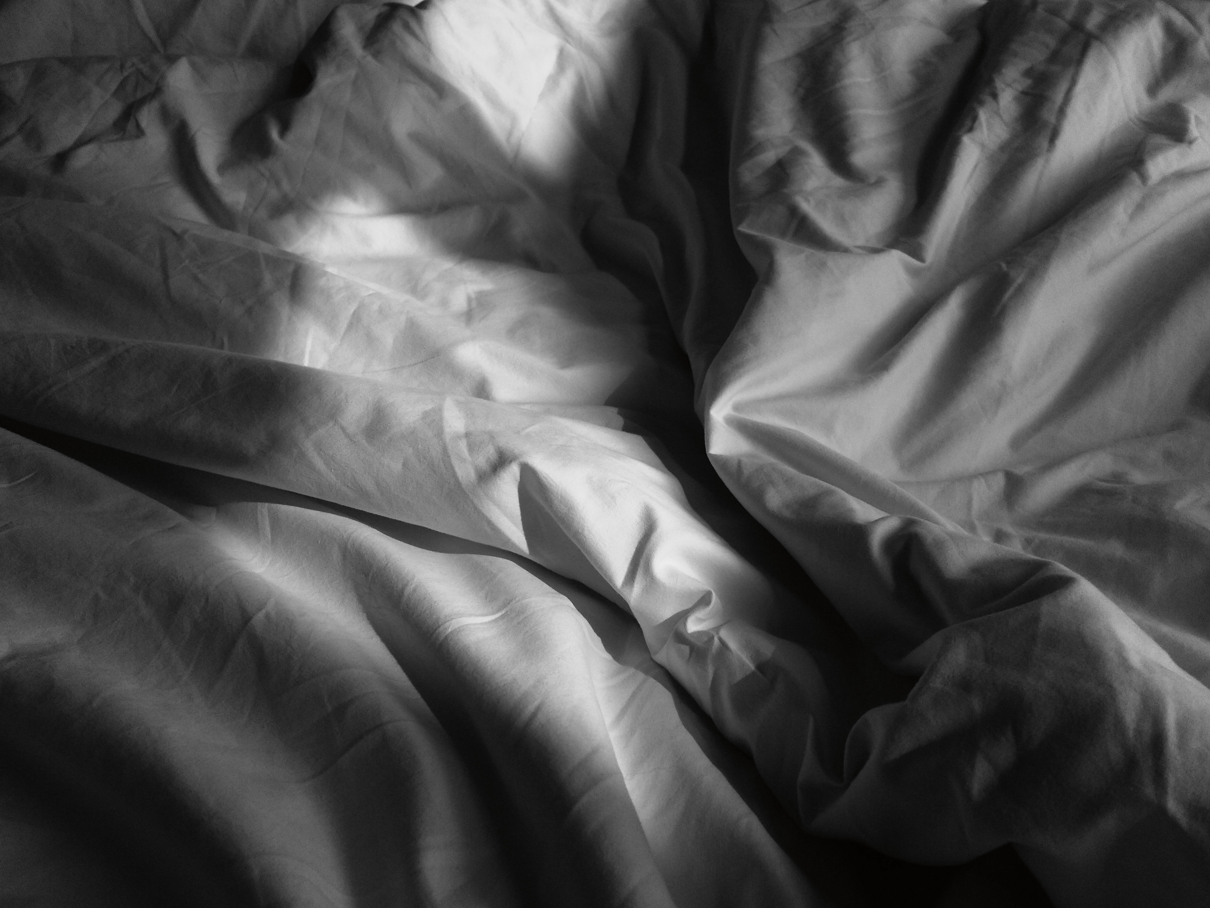 Photograph of rumpled bed sheets