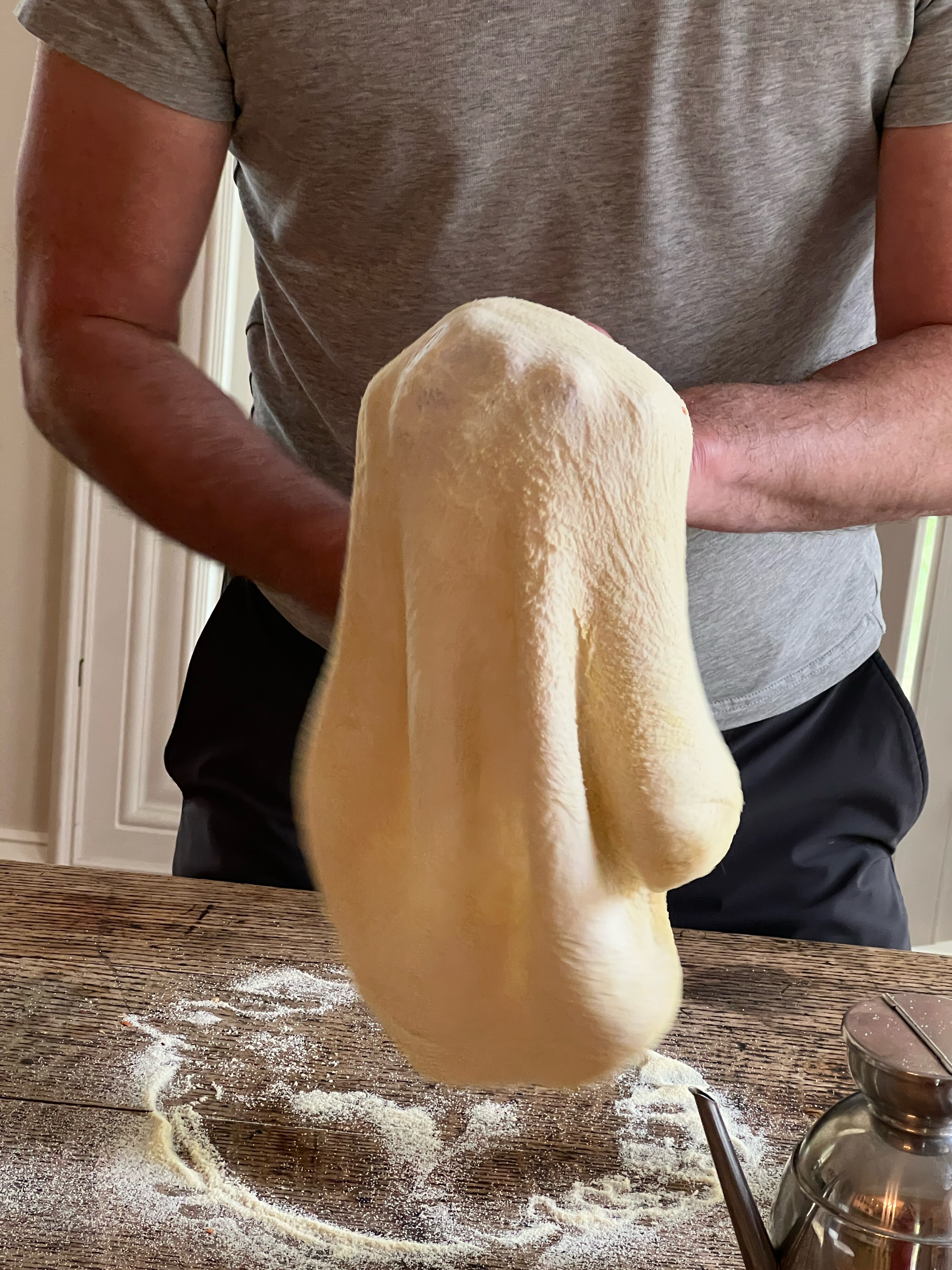 A cook stretches pizza dough